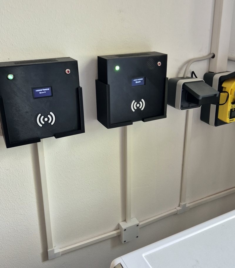 Zwei selbst gebaute Terminals an der Wand des Waschkellers, daneben die Messstecker der Maschinen